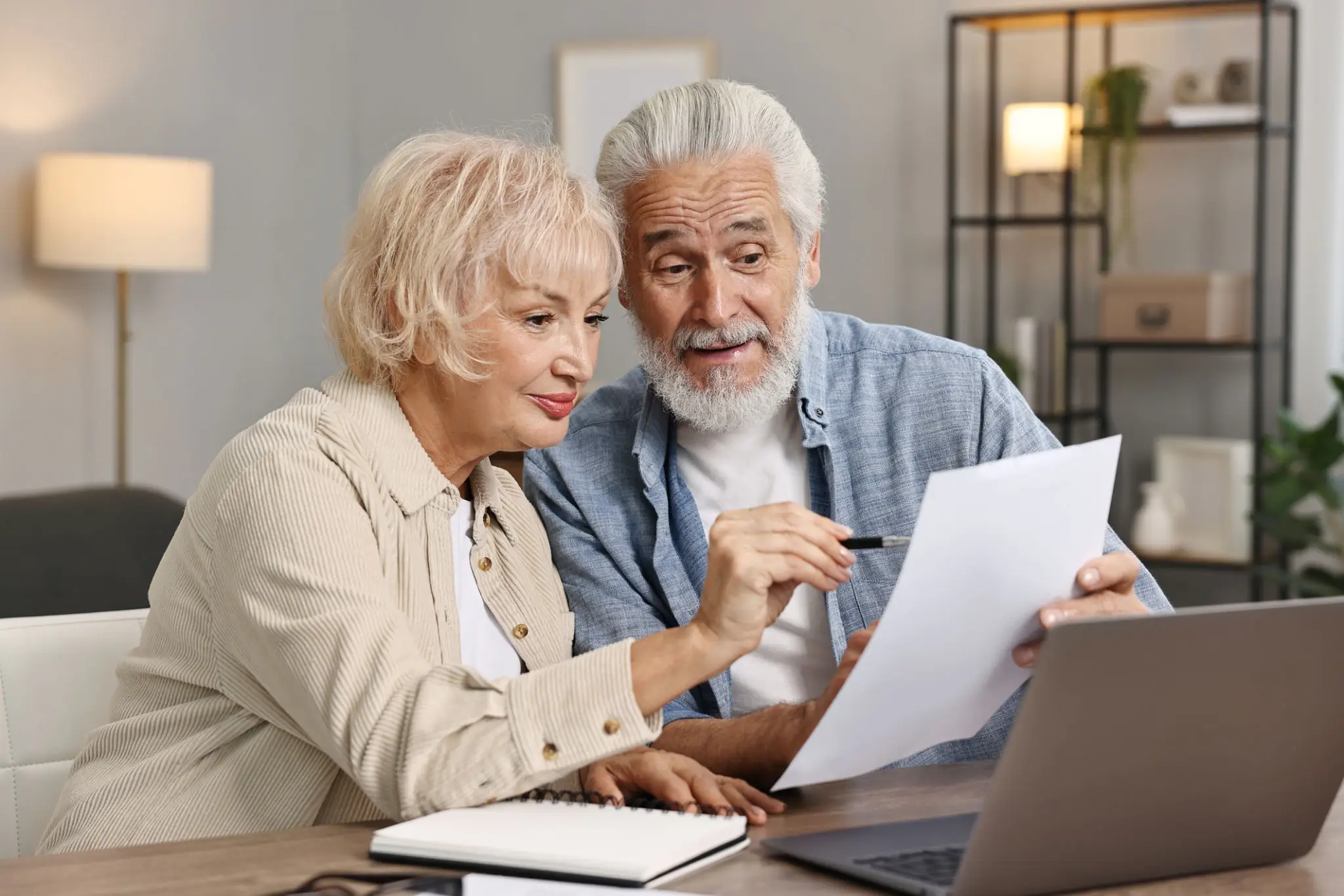An elderly couple reviewing documents together at home.