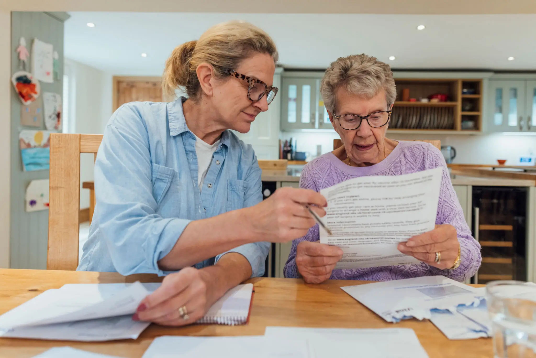 Two women reviewing documents together at a table.