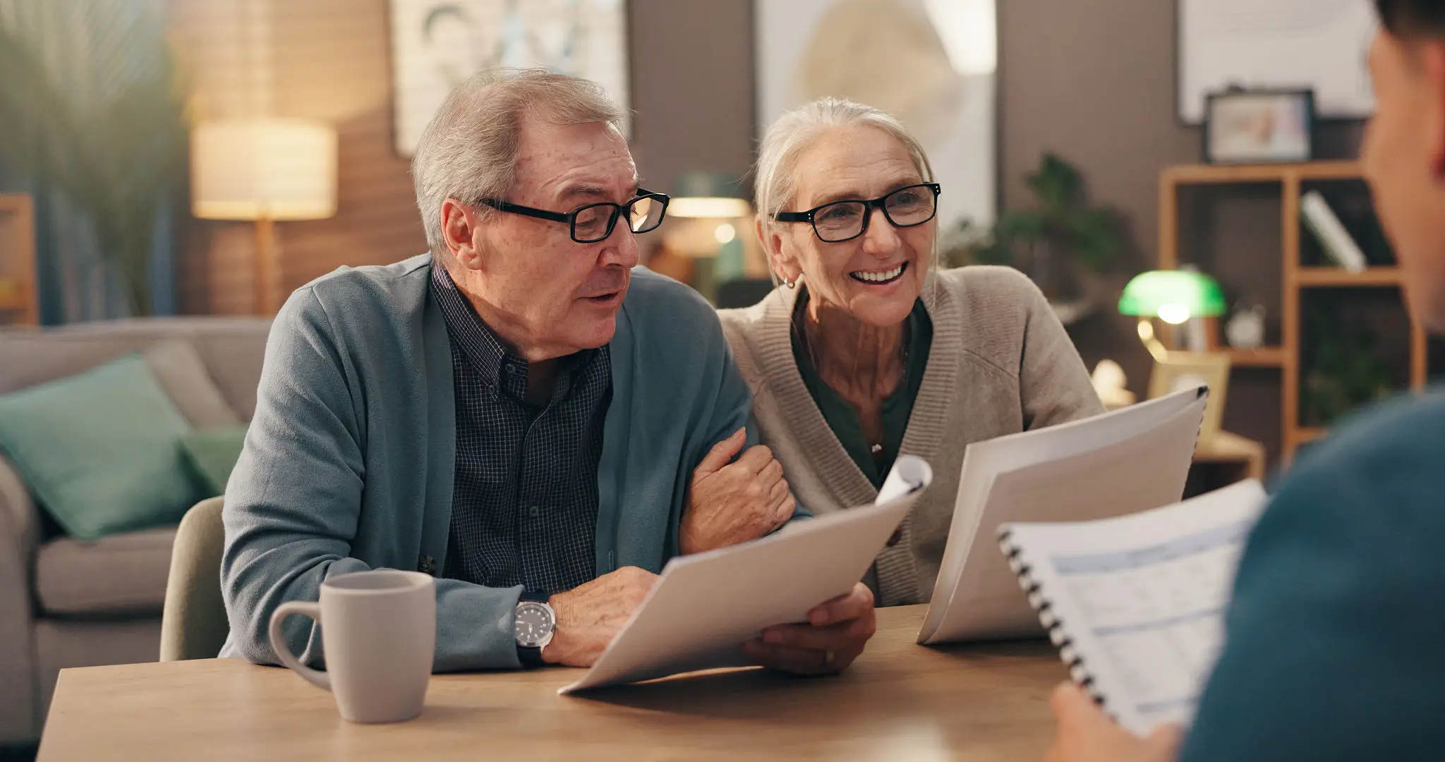 Elderly couple reviewing documents together at home.