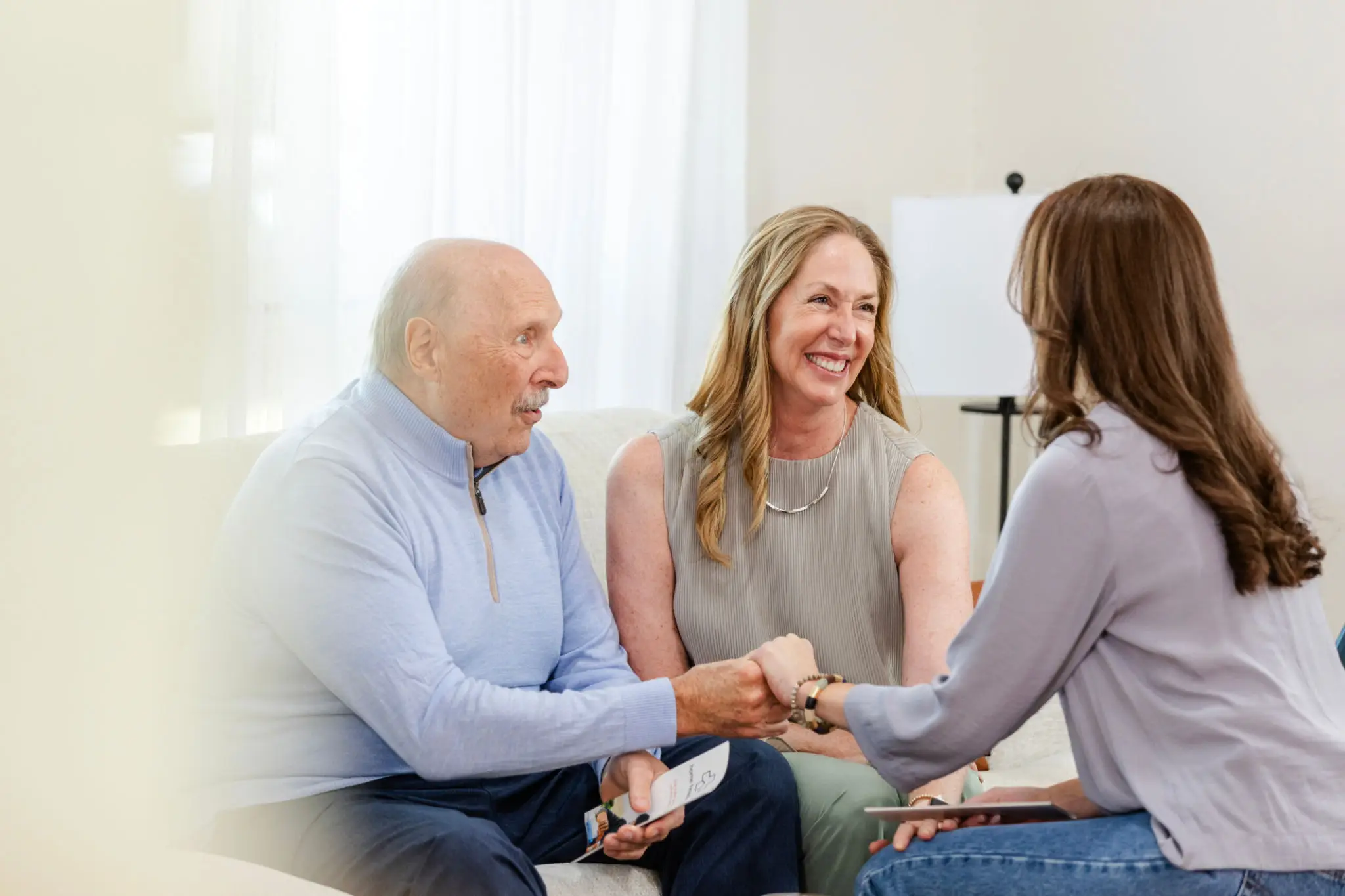 Couple consulting with a female therapist in a bright room.